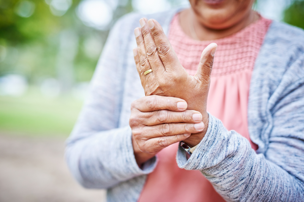 Elderly woman with her hands together indicating arthritis in her left hand